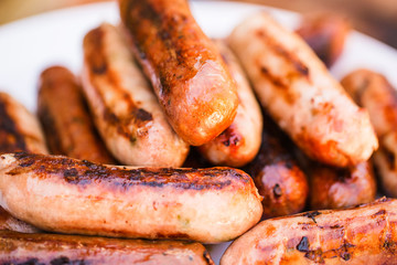 Barbecued beef and pork sausages on white plate
