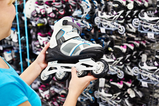 Woman chooses roller skates in sports shop