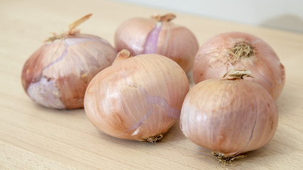 Some onions on a bright wooden table