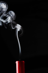 Extinguished candle with smoke trailing off the wick