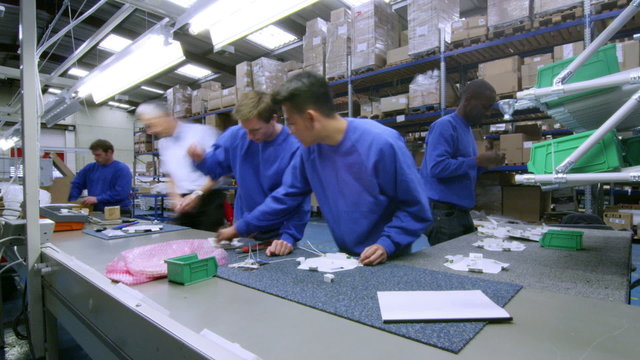 Time lapse of workers on an assembly line making lighting components