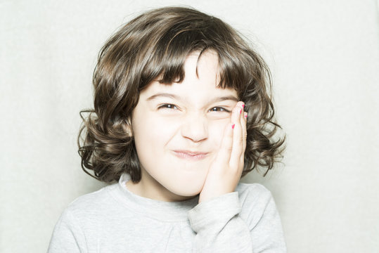 Ni&ntilde;a toc&aacute;ndose la cara
