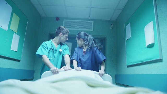 Hospital emergency team rush a patient on a gurney to the operating theatre