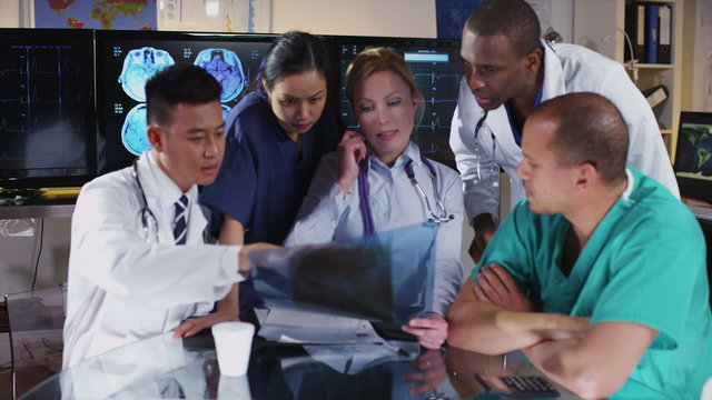 Group of colleagues in a medical meeting discuss a patient's x ray results