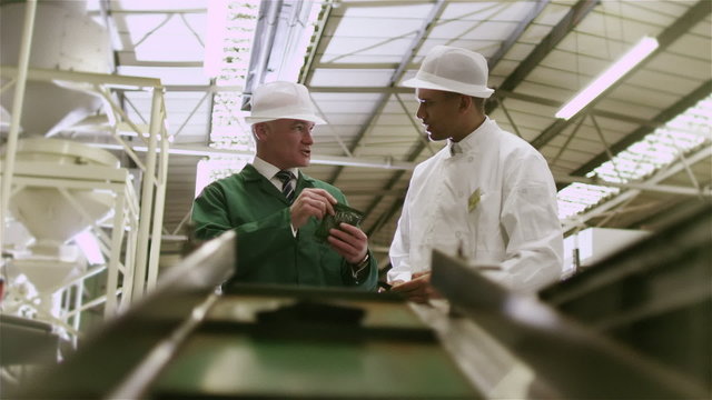 Workers in a factory quality checking packets of fresh coffee