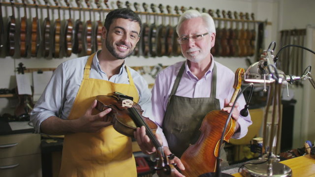 Father and son shopping together, looking at violins in a musical store