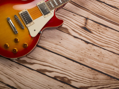 An electric guitar on a wood background