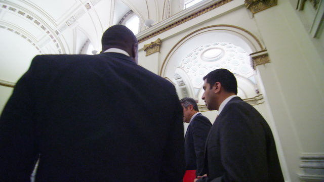 Business or political delegates chat as they walk through conference building