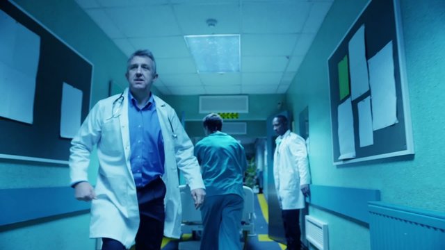 Hospital emergency team rush a patient on a gurney to the operating theatre