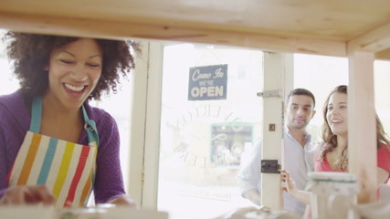 Attractive ethnic female shopkeeper provides service with a smile