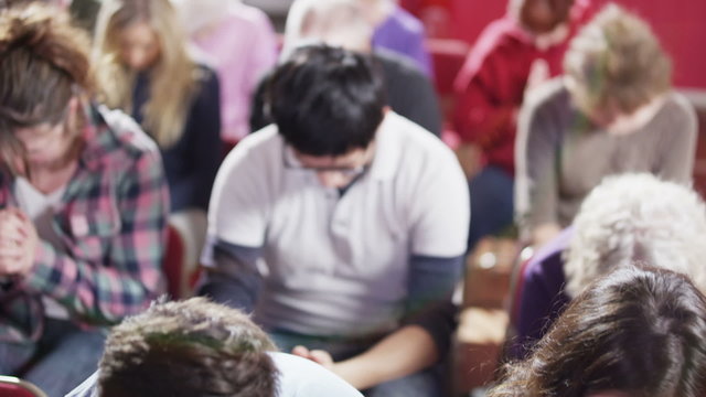 Church group bow their heads to pray