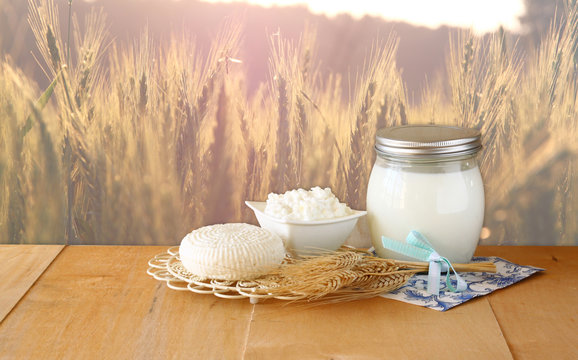 Tzfatit cheese , cottage and milk on wooden table  over wheat fi