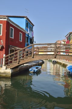 Rustic wooden bridge in canal in Burano,  Venice, Italy