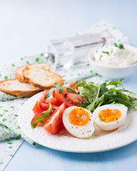 Fototapeta na wymiar Breakfast with soft-boiled egg, arugula and tomatoes