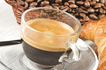 coffee in glass cup with croissants and coffee beans