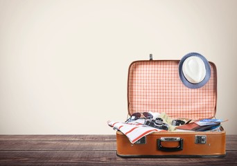 Travel. Retro tourist luggage with colorful clothes and