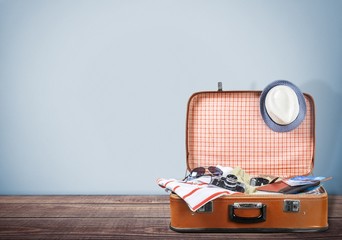 Travel. Retro tourist luggage with colorful clothes and