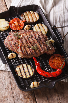 beef steak grilled with onions, eggplant and chilli in pan grill