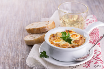 Baked eggs in cheese sauce with bread and wine