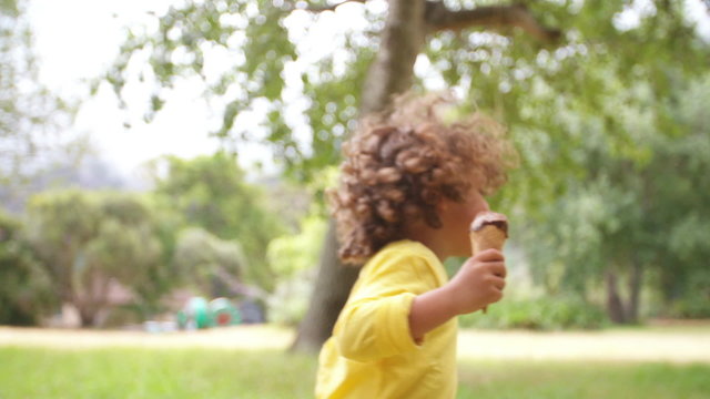 Happy African American boy having an ice cream in the park