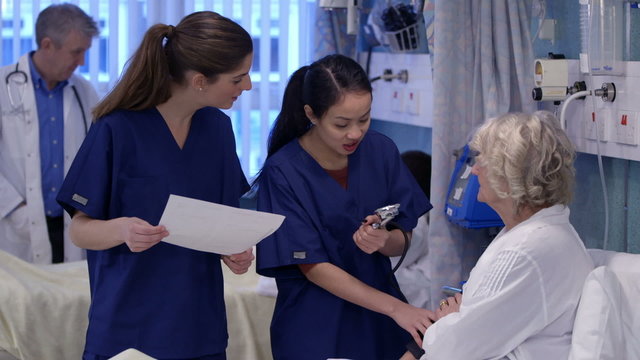 Medical staff working together and taking care of patients on a hospital ward.