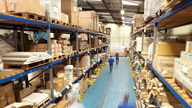 Time lapse of male workers in warehouse preparing goods for dispatch