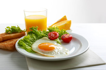 Bacon and eggs on color wooden table background