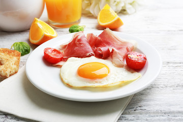 Bacon and eggs on color wooden table background.