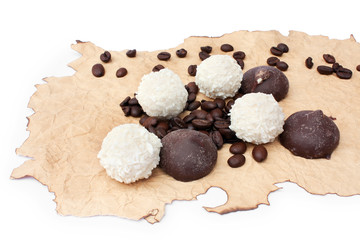 candys and grains of coffee on a singed paper