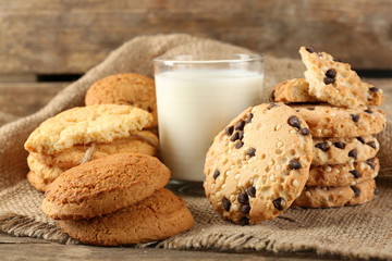 Tasty cookies and glass of milk on rustic wooden background