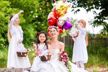 Braut im Brautkleid mit Blumenkindern