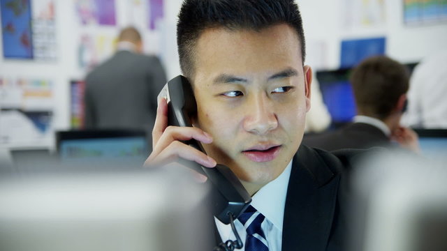 Young and ambitious stock market trader doing a deal over the phone
