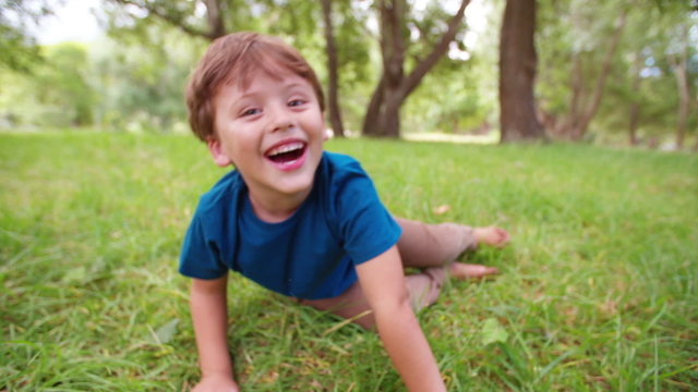 Boy rolling in grass in slow motion