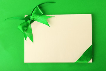 Card decorated with bow on green background