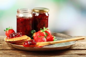 Jars of strawberry jam with berries and wafers