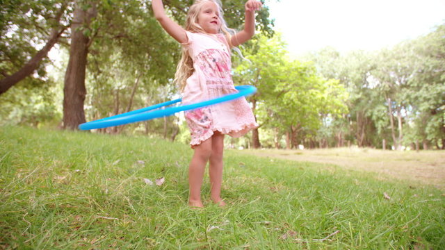 Girl trying to hula hoop in park