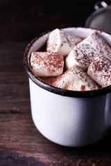 Mug of cocoa with marshmallows on wooden background