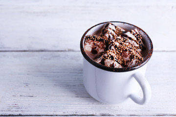 Mug of cocoa with marshmallows on wooden background
