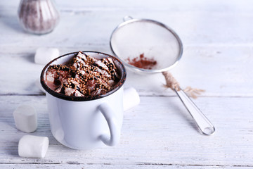 Mug of cocoa with marshmallows on wooden background