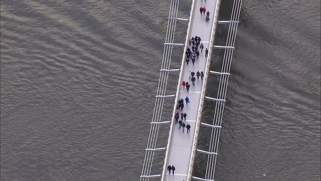 Aerial view of pedestrians crossing London's Millennium bridge