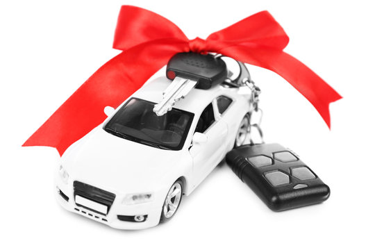 Keys with red bow on car as present isolated on white