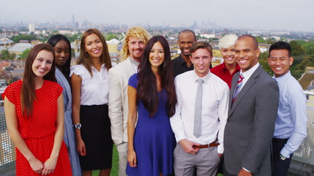 Portrait of attractive smiling business team with city view in the background