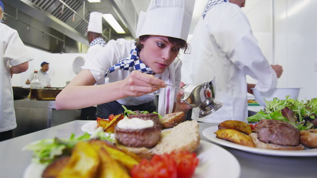 Delicious meal being given the finishing touches by chef in a commercial kitchen