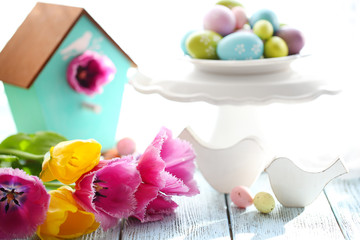 Easter decoration, eggs and tulips on table on bright