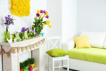 Fireplace with beautiful spring decorations in room
