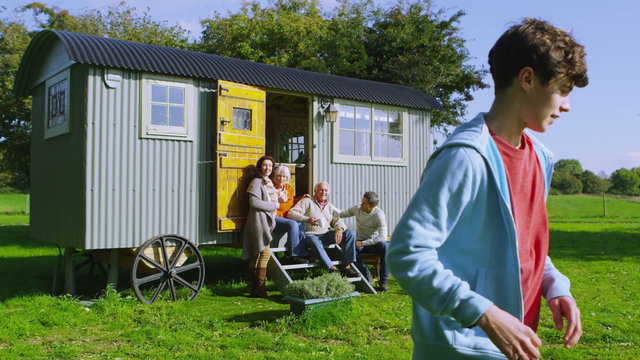 Cheerful family relaxing together outside quaint caravan in a natural setting