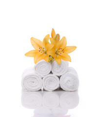 Fototapeta na wymiar yellow lily on stacked roller towels