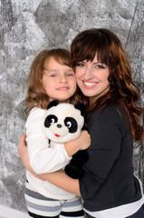 young mother hugging her little daughter indoors