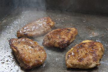 Chicken escalope panne cooking on grill in restaurant