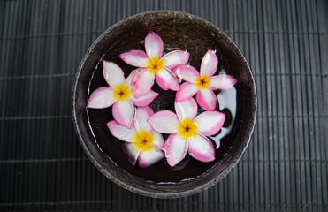 Obraz na płótnie Canvas many frangipani in wooden bowl on mat